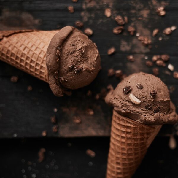 2 waffle cones with a ball of chocolate and coconut milk ice-cream with a sprinkle of cacao nibs