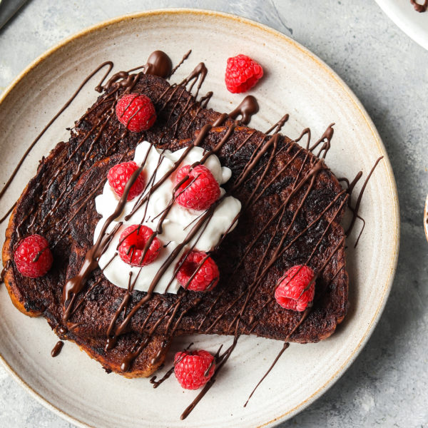two slices of chocolate french toast with yoghurt and raspberries on plate