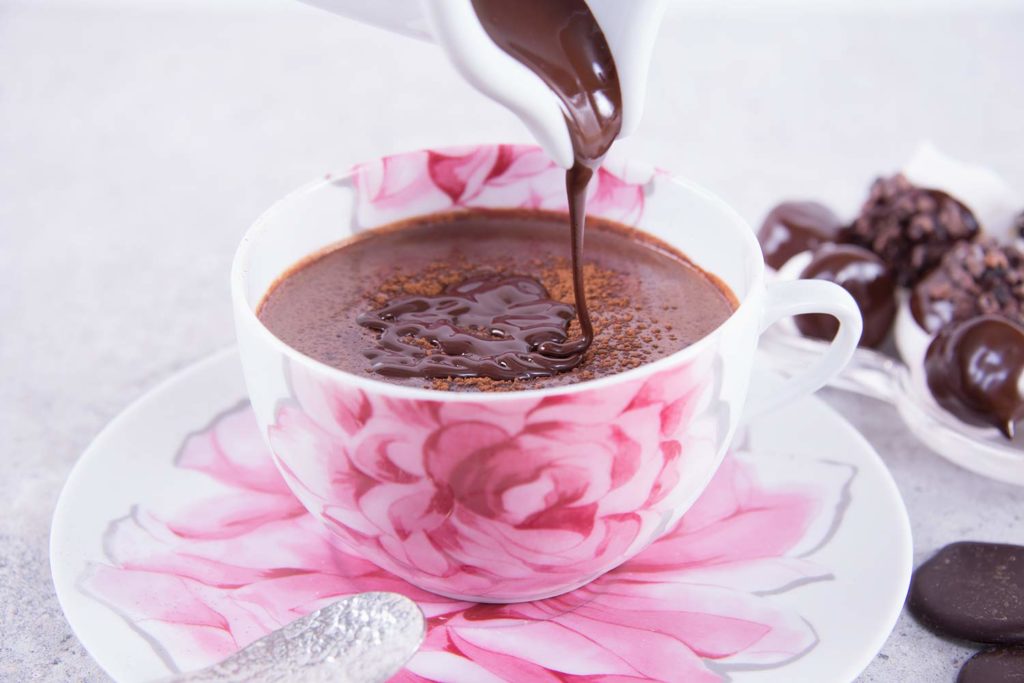 a cup of hot chocolate with melted chocolate being pured