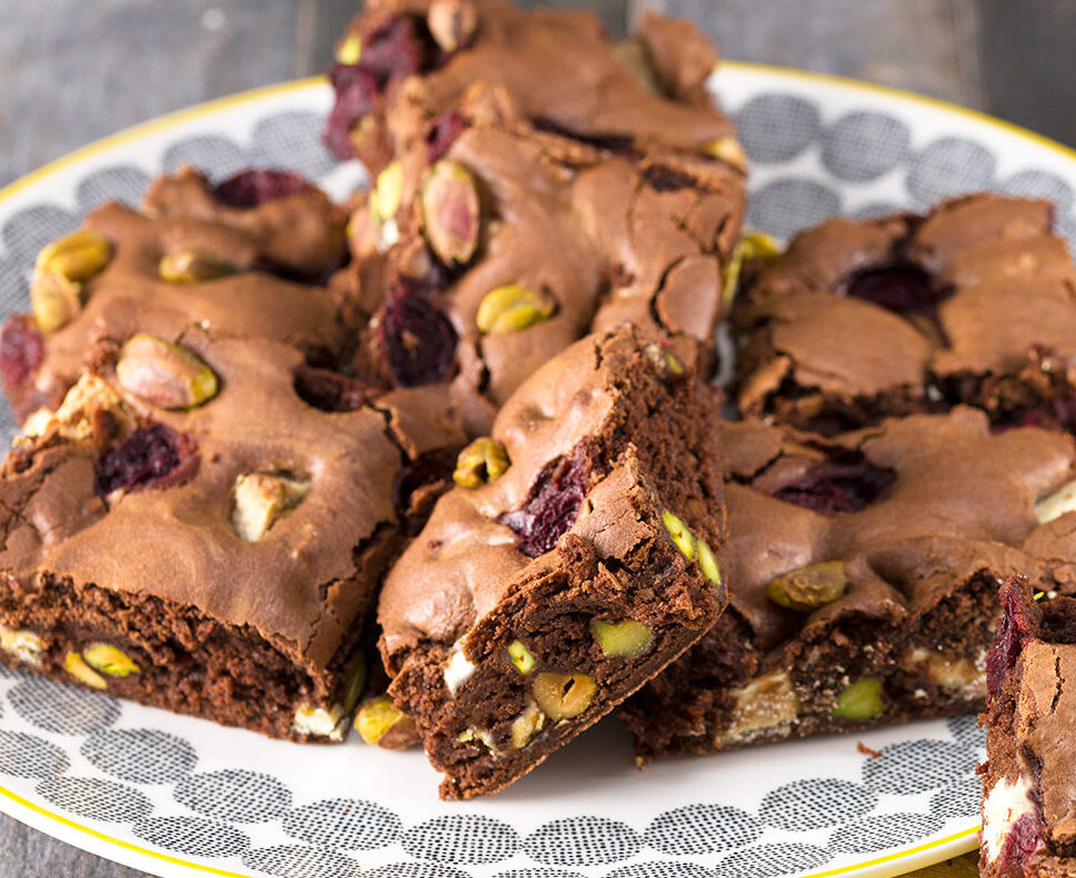 white & dark chocolate brownies with nuts and fruits on a plate