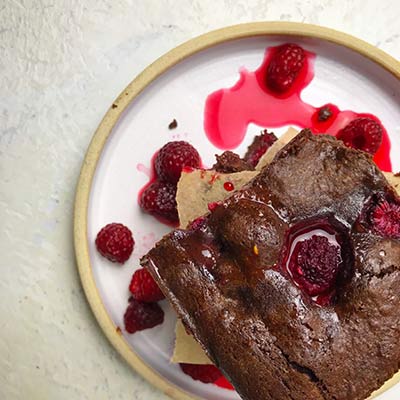 Chocolate raspberry brownies on a plate shown from above