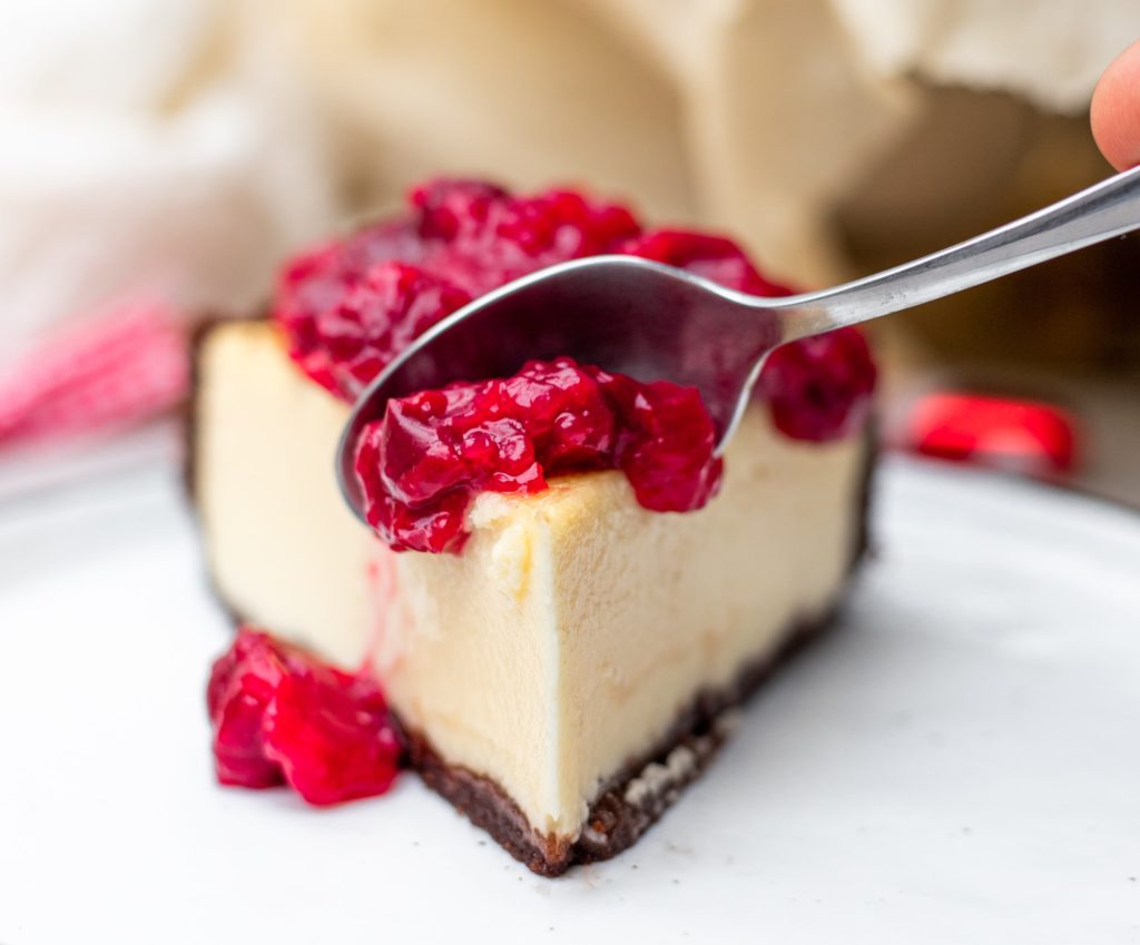 white chocolate strawberry cheesecake slice with a spoon
