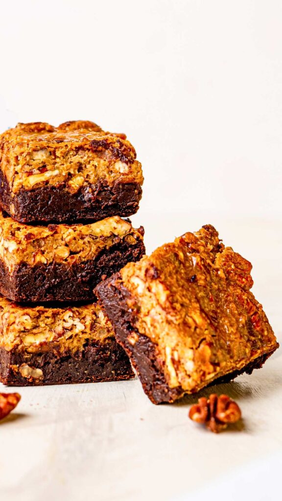 pecan pie brownies cut up in squares and stalked up looking delicious